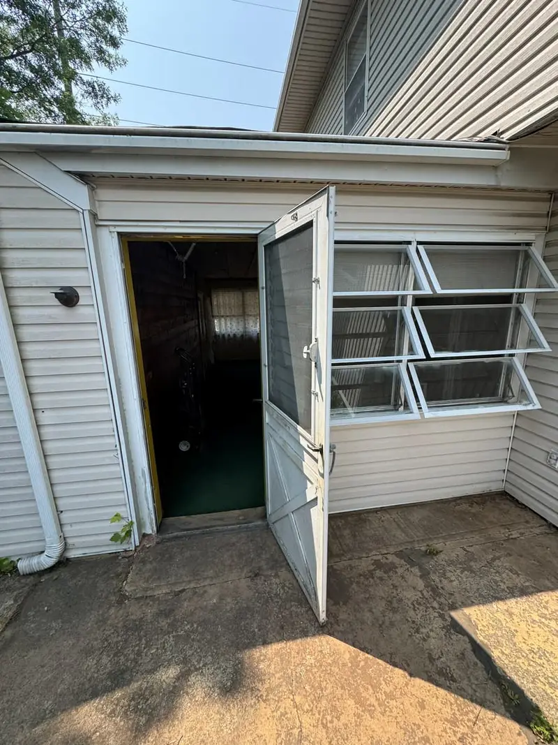 Back door off a concrete patio between two wings, Levittown, NY
